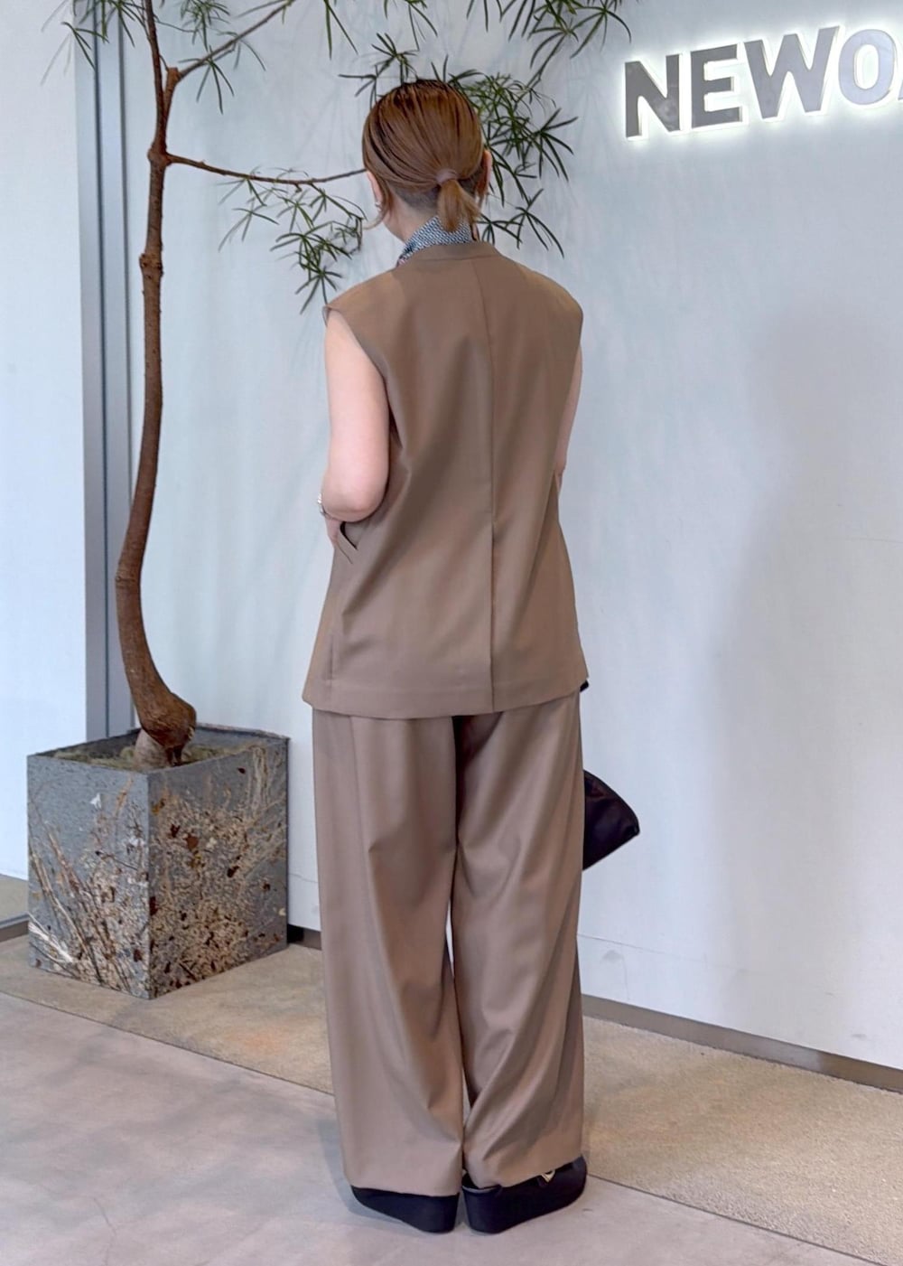 ベージュ系のベスト、ベージュ系のその他パンツ、ブラック系のショルダーバッグを着用したレディースの秋コーディネートの5枚目の写真