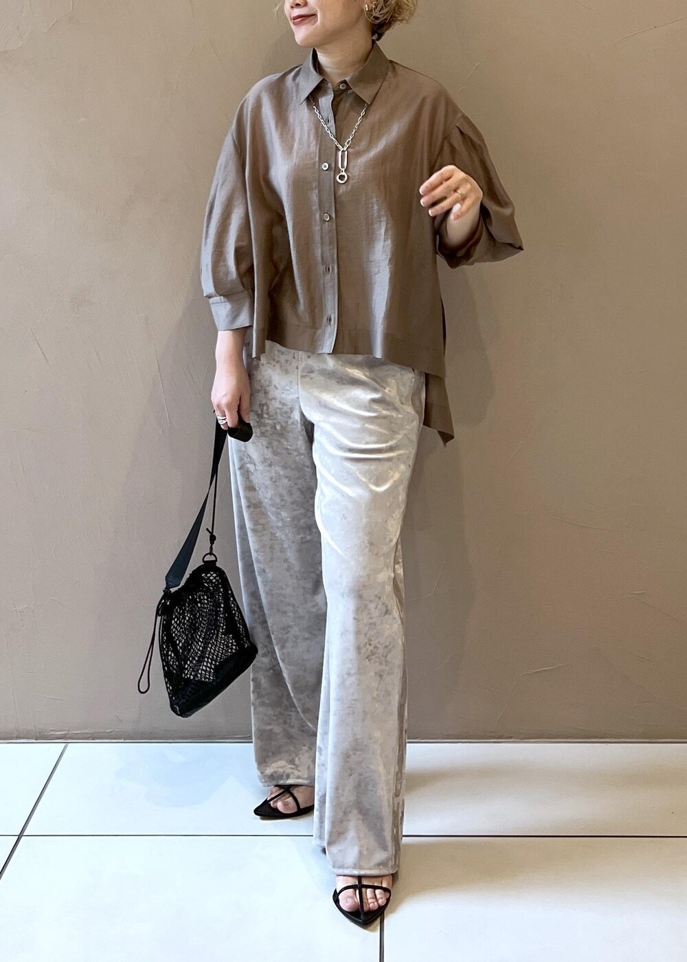 ベージュ系のその他パンツ、ブラック系のサンダル、ブラウン系のシャツ/ブラウスを着用したレディースの春コーディネートの5枚目の写真