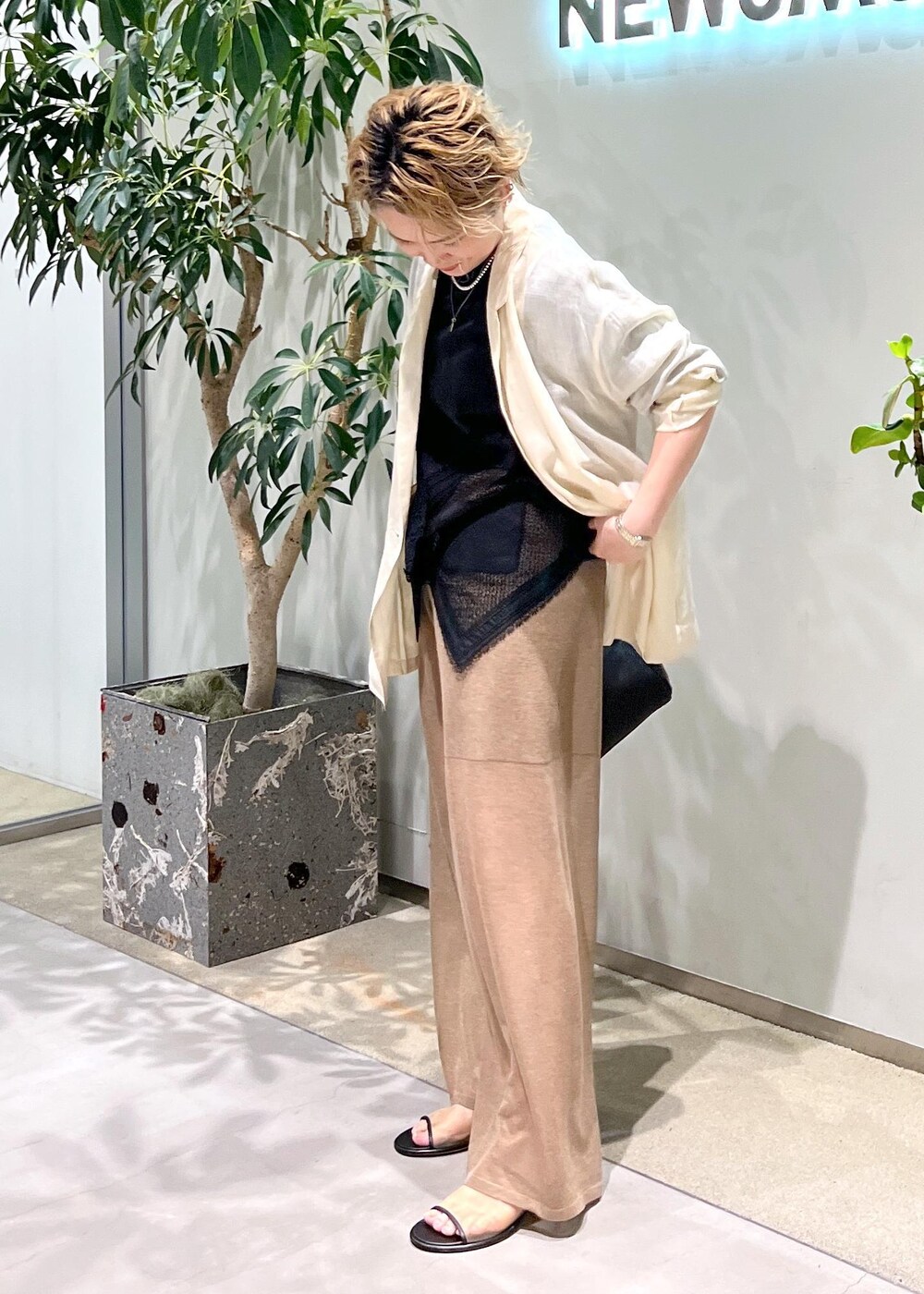 ブラック系のショルダーバッグ、ブラック系のTシャツ/カットソー、ホワイト系のテーラードジャケットを着用したレディースの夏コーディネートの4枚目の写真