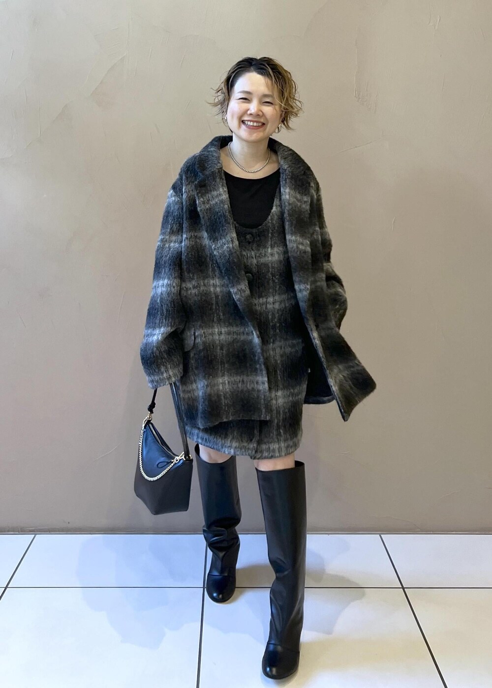 グレー系のジャンパースカート、グレー系のその他アウター、ブラック系のTシャツ/カットソーを着用したレディースの秋コーディネートの3枚目の写真