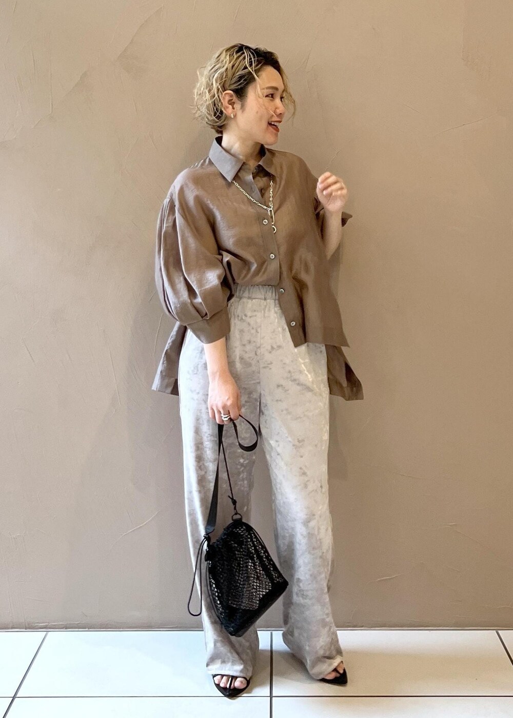 ベージュ系のその他パンツ、ブラック系のサンダル、ブラウン系のシャツ/ブラウスを着用したレディースの春コーディネートの3枚目の写真