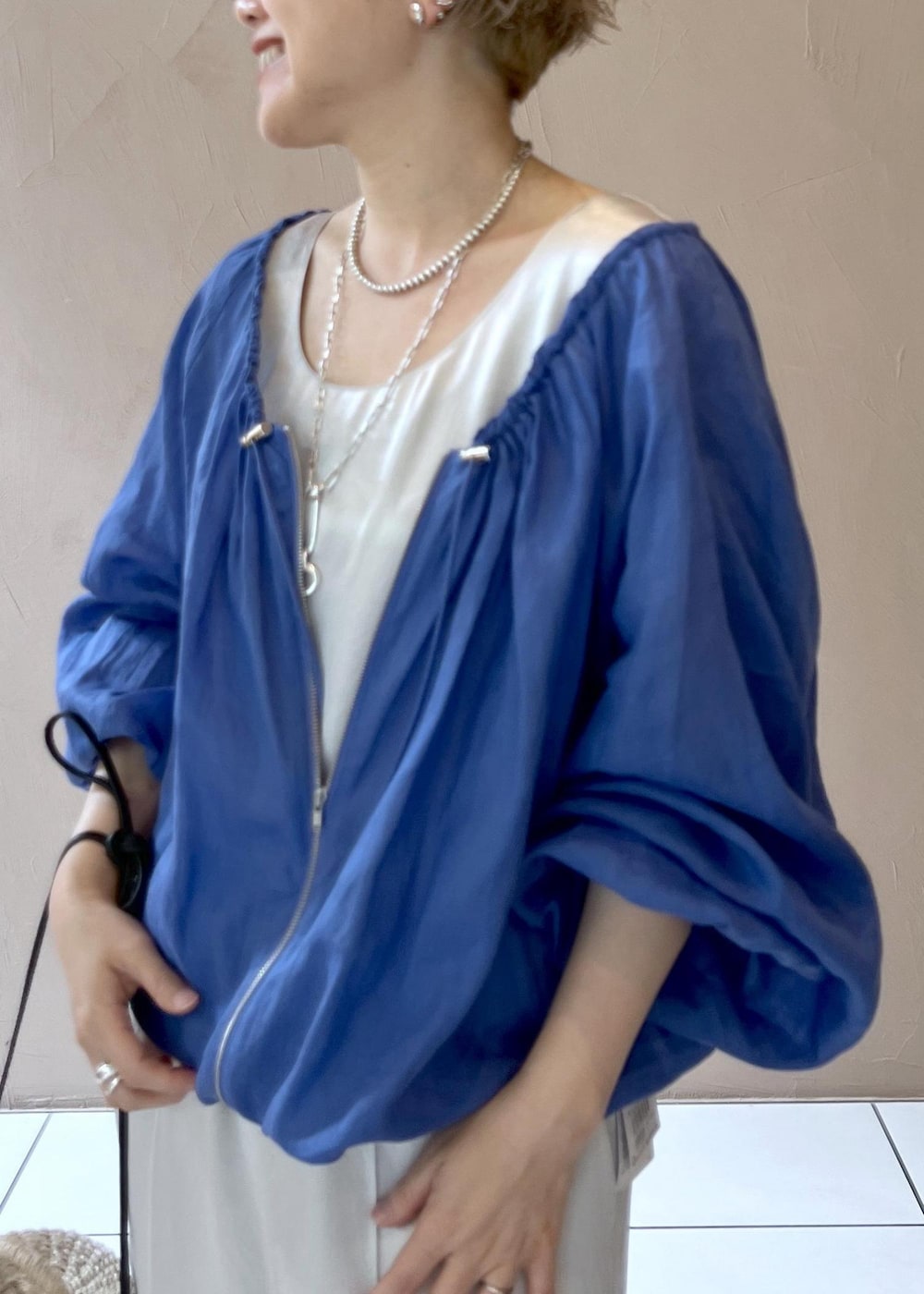 ホワイト系のショルダーバッグ、ブルー系のブルゾン、ホワイト系のつなぎ/オールインワンを着用したレディースの夏コーディネートの6枚目の写真