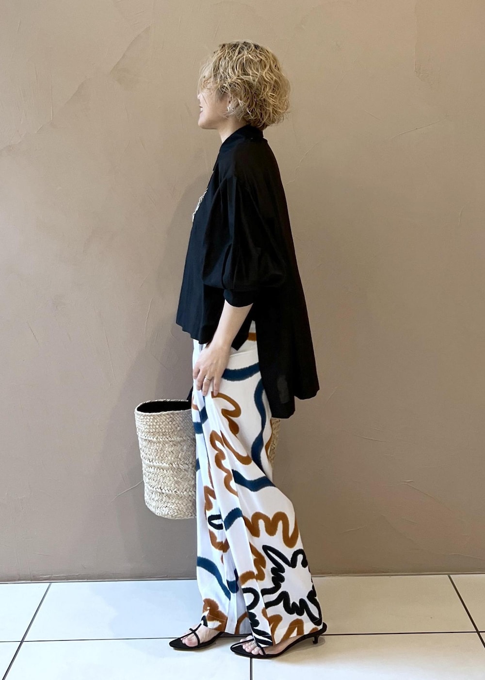 ブラック系のサンダル、ホワイト系のかごバッグ、ブラック系のシャツ/ブラウスを着用したレディースの春コーディネートの5枚目の写真