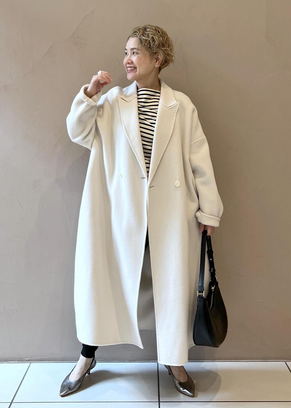 ホワイト系のその他アウター、シルバー系のパンプス、ブラック系のその他パンツを着用したレディースの秋コーディネートの3枚目の写真