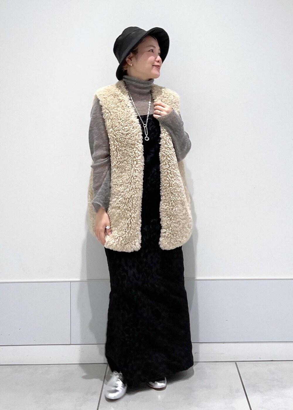 ベージュ系のベスト、ブラック系のワンピース、グレー系のニット/セーターを着用したレディースの秋コーディネートの6枚目の写真