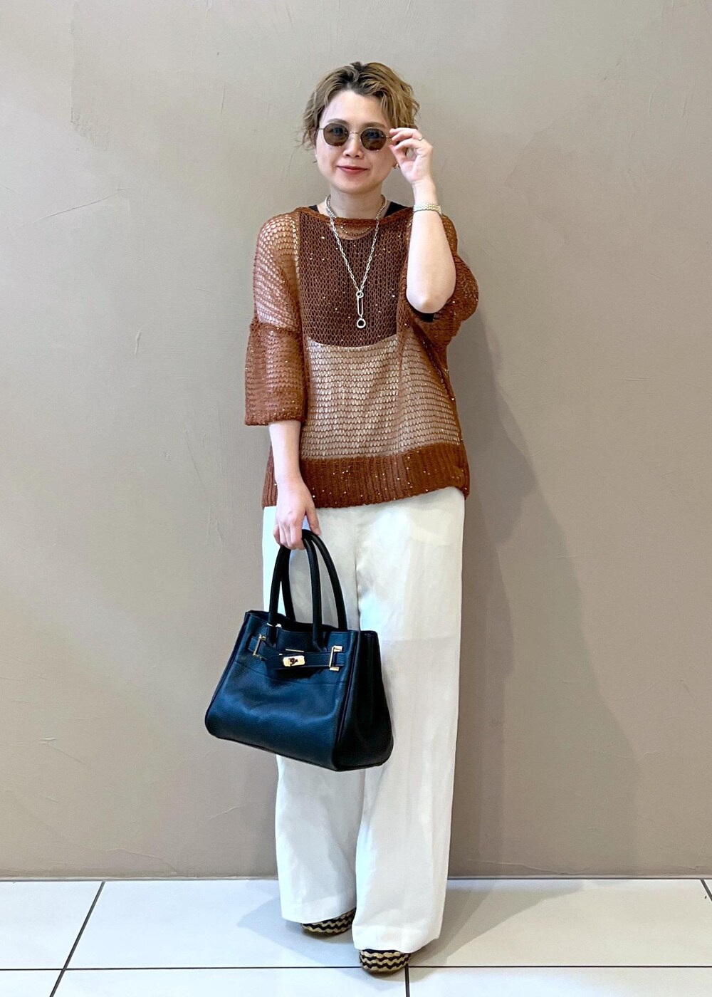 ホワイト系のサロペット/オーバーオール、グレー系のタンクトップ、ブラック系のショルダーバッグを着用したレディースの夏コーディネートの4枚目の写真