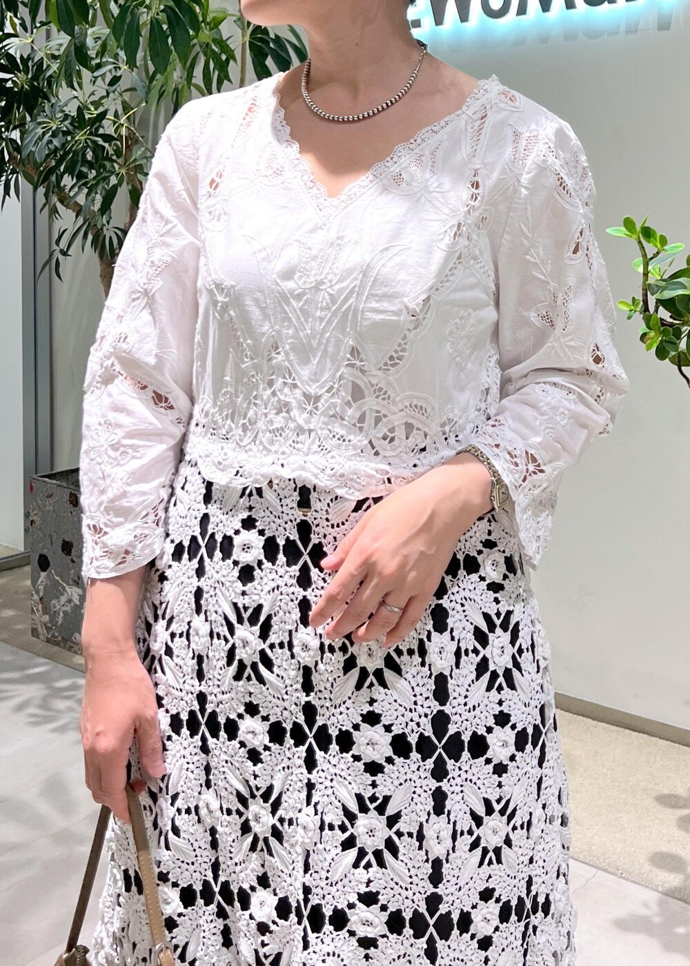 ブラック系のスラックス、ブルー系のシャツ/ブラウス、ブラウン系のショルダーバッグを着用したレディースの夏コーディネートの6枚目の写真