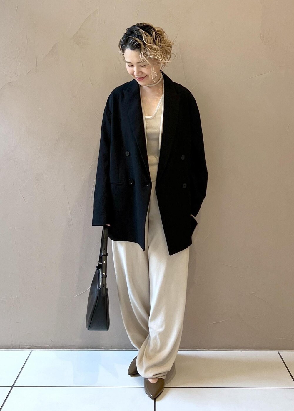 ブラック系のテーラードジャケット、ブラウン系のパンプスを着用したレディースの秋コーディネートの4枚目の写真