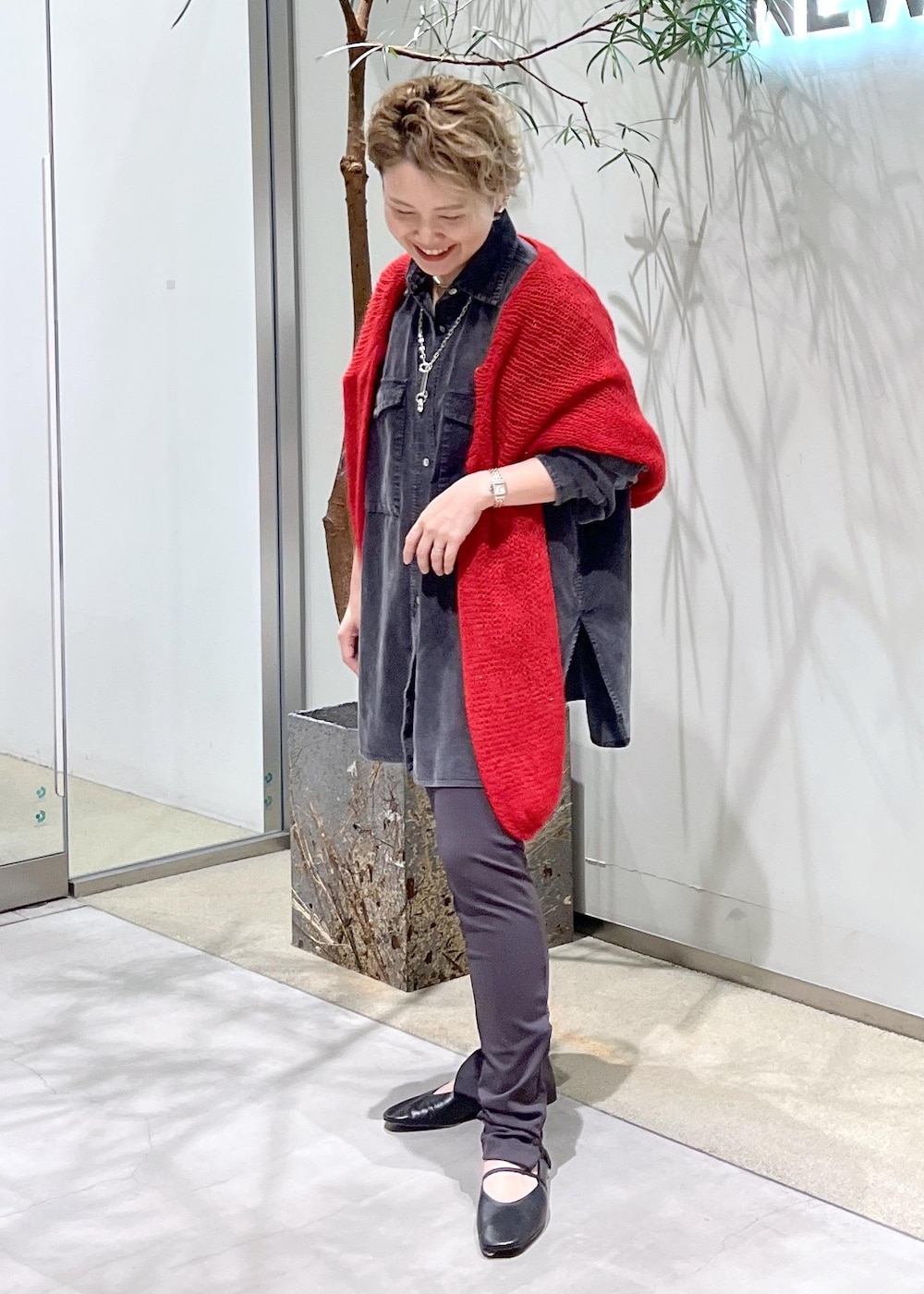グレー系のシャツ/ブラウス、ブラック系のパンプス、レッド系のニット/セーターを着用したレディースの秋コーディネートの5枚目の写真