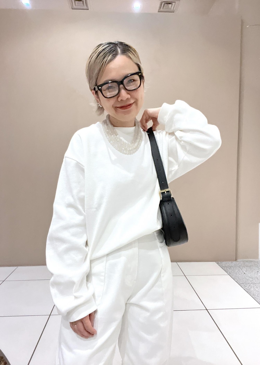 ホワイト系のデニムパンツ、ブラック系のショルダーバッグを着用したレディースの夏コーディネートの6枚目の写真