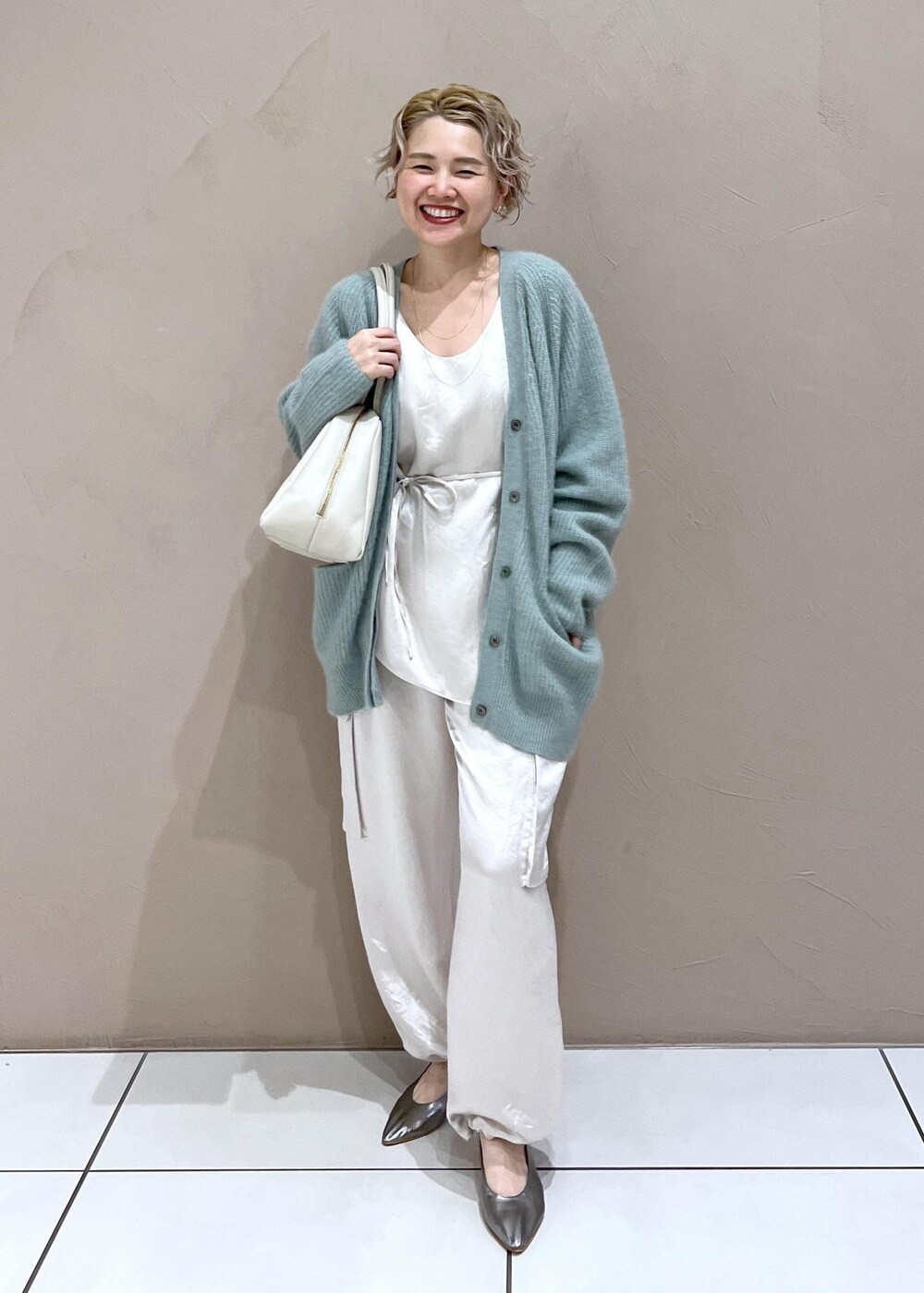 ホワイト系のTシャツ/カットソー、グリーン系のカーディガン/ボレロ、ホワイト系のカーゴパンツを着用したレディースの秋コーディネートの10枚目の写真