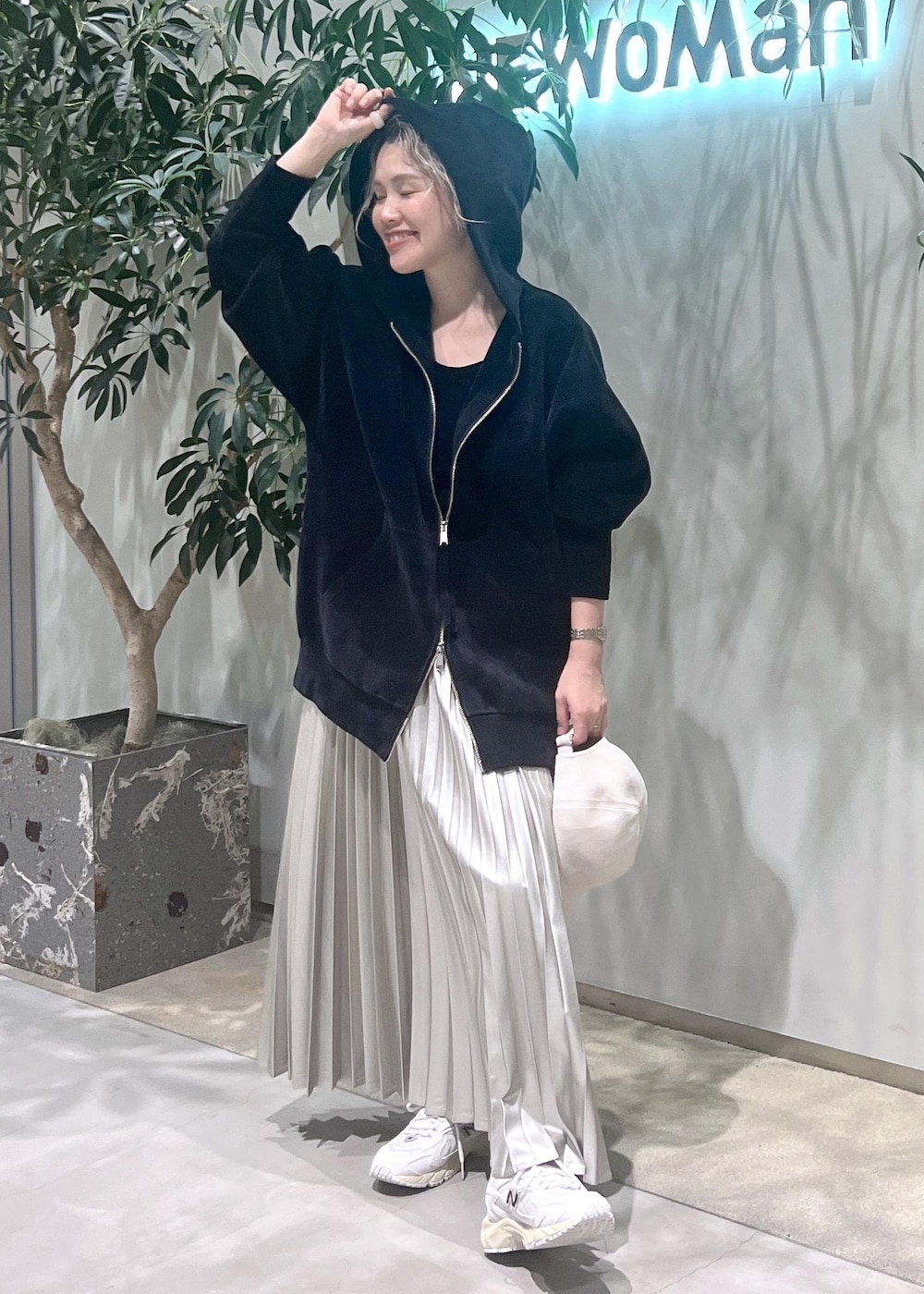 ベージュ系のスカート、ブラック系のタンクトップ、ブラック系のパーカーを着用したレディースの秋コーディネートの5枚目の写真