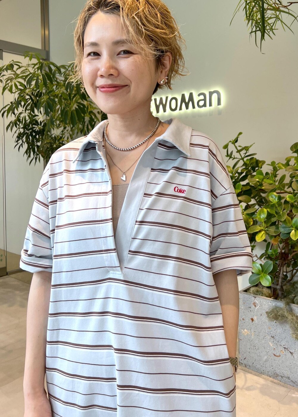 ブラウン系のボストンバッグ、ホワイト系のサンダル、ブルー系のワンピースを着用したレディースの夏コーディネートの6枚目の写真