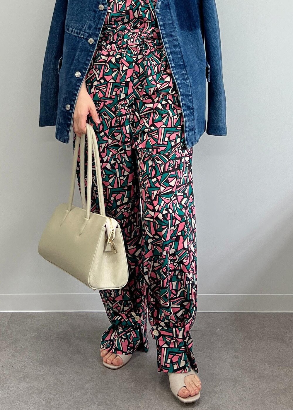 ホワイト系のボストンバッグ、グレー系のサンダル、グリーン系のつなぎ/オールインワンを着用したレディースの春コーディネートの8枚目の写真