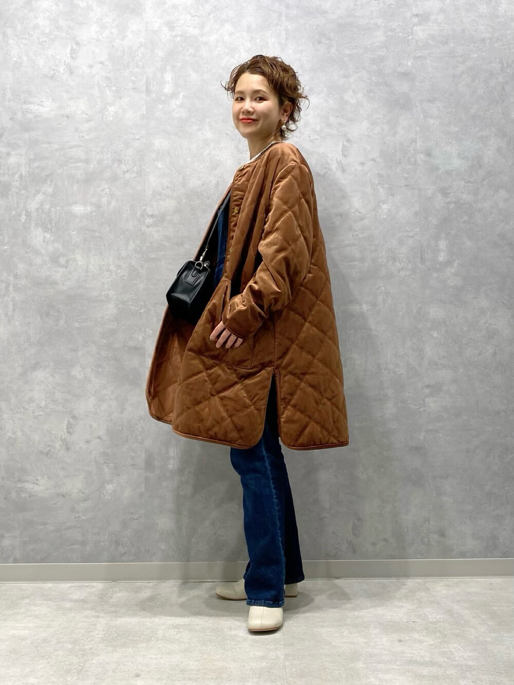 ブラウン系のブルゾン、ブルー系のサロペット/オーバーオール、ホワイト系のブーツを着用したレディースの秋コーディネートの3枚目の写真