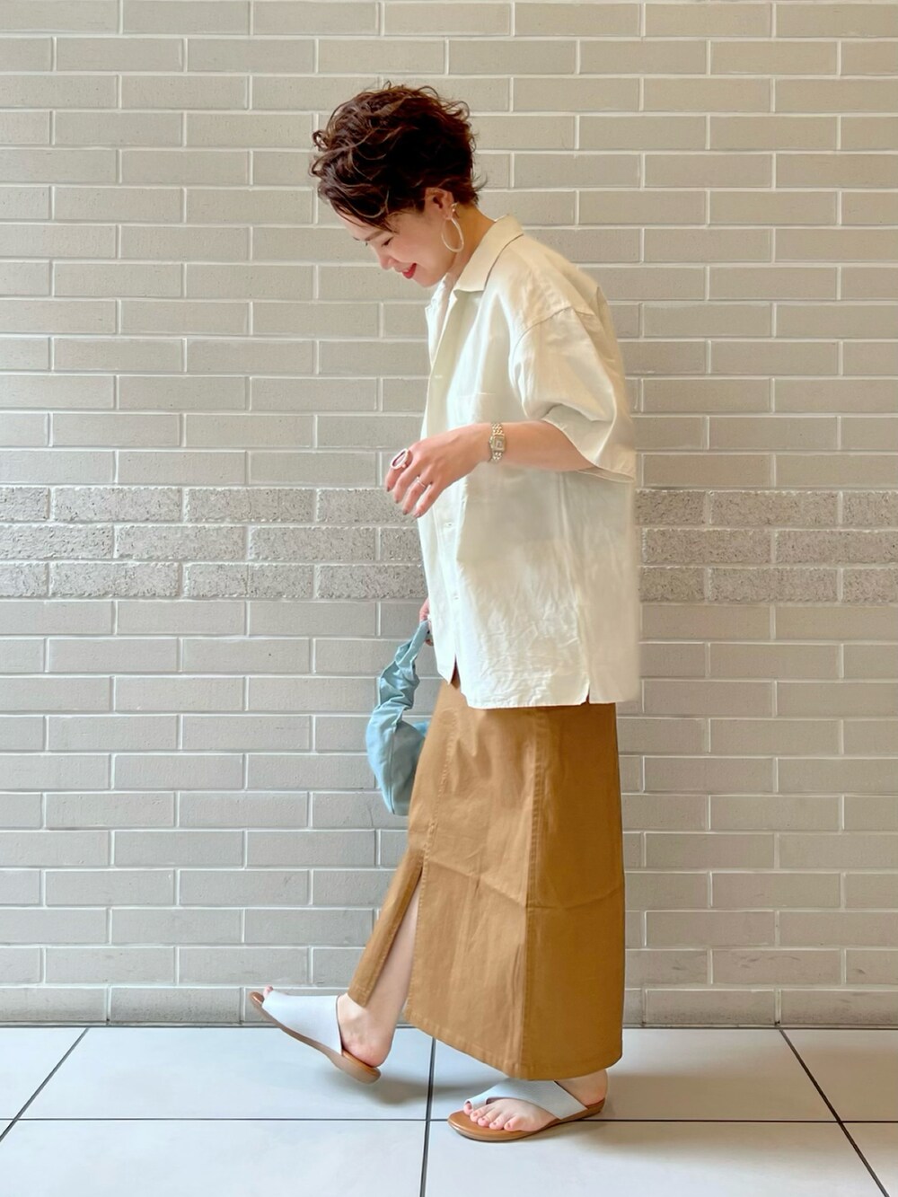 ホワイト系のシャツ/ブラウス、ホワイト系のキャミソール、イエロー系のスカートを着用したレディースの夏コーディネートの3枚目の写真