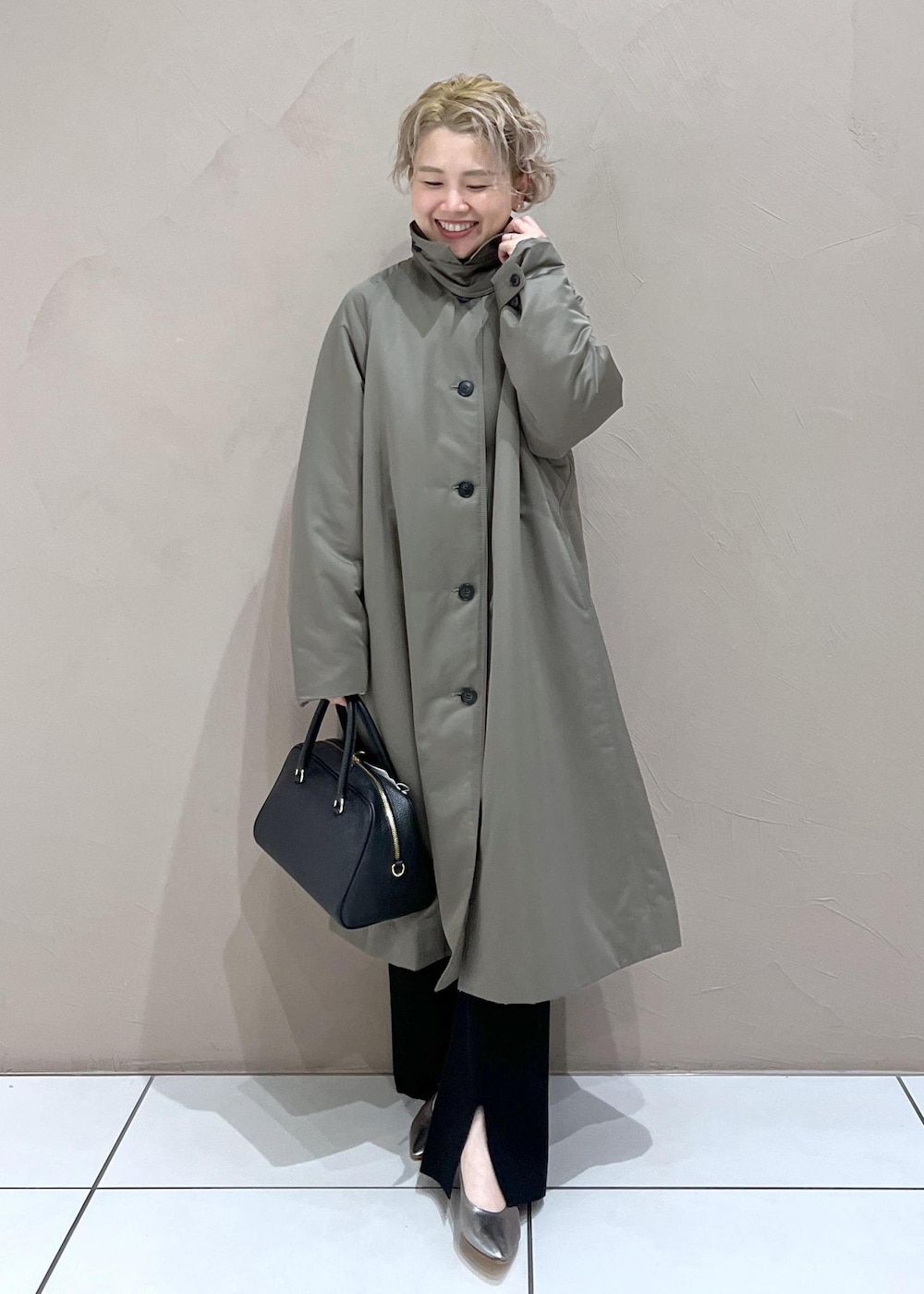 ブラック系のボストンバッグ、グリーン系のダウンジャケット/コート、ブラック系のその他パンツを着用したレディースの秋コーディネートの2枚目の写真