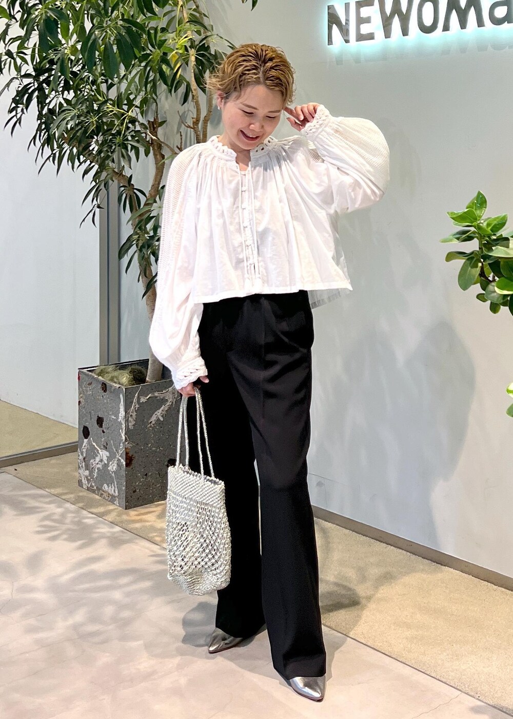 ブラック系のその他パンツ、シルバー系のトートバッグ、ホワイト系のシャツ/ブラウスを着用したレディースの夏コーディネートの2枚目の写真