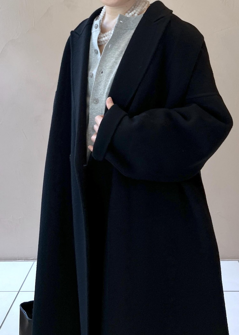 ブラック系のハンドバッグ、ブラック系のその他アウター、シルバー系のパンプスを着用したレディースの秋コーディネートの7枚目の写真