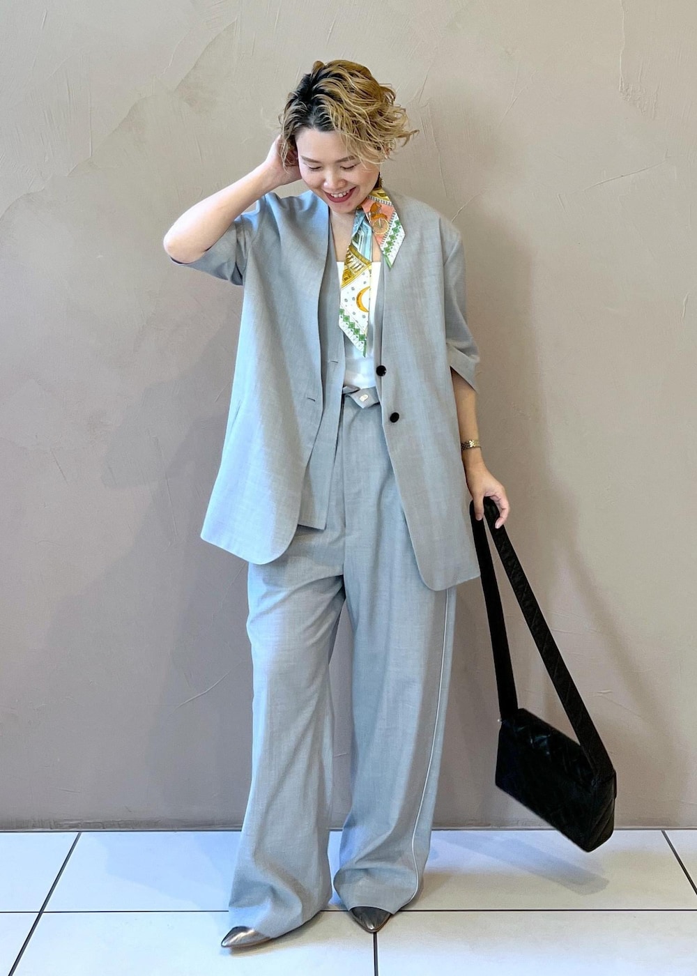 グレー系のベスト、グレー系のスラックス、グレー系のテーラードジャケットを着用したレディースの冬コーディネートの10枚目の写真