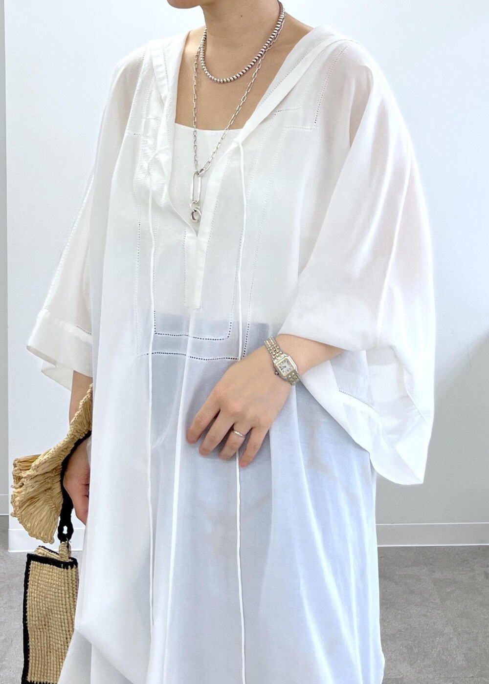 ブラック系のサンダル、ホワイト系のワンピース、ブルー系のその他パンツを着用したレディースの春コーディネートの7枚目の写真