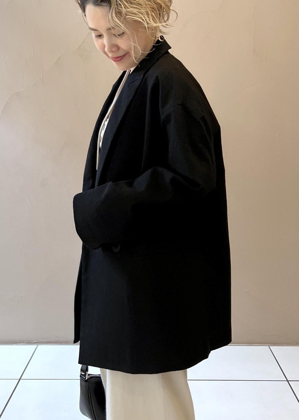 ブラック系のテーラードジャケット、ブラウン系のパンプスを着用したレディースの秋コーディネートの6枚目の写真