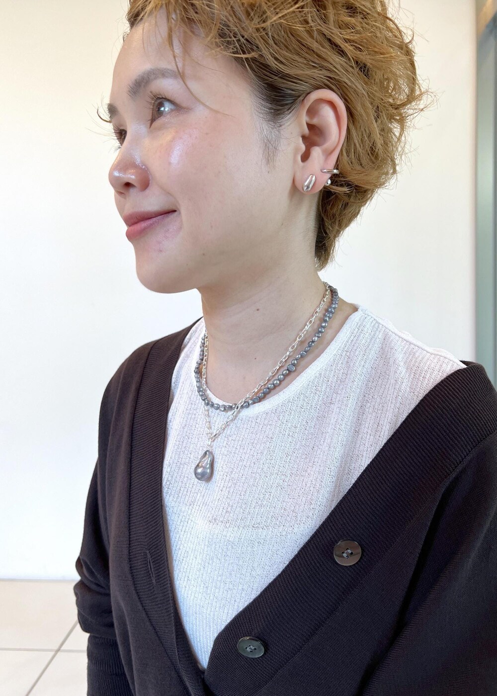 ブラック系のサンダル、ブラウン系のカーディガン/ボレロ、ブルー系のデニムパンツを着用したレディースの夏コーディネートの7枚目の写真