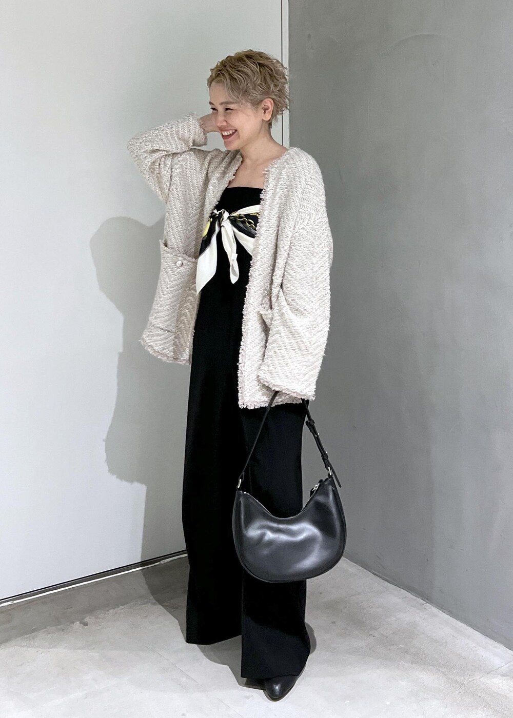 ブラック系のつなぎ/オールインワン、ベージュ系のカーディガン/ボレロ、ブラック系のブーツを着用したレディースの秋コーディネートの6枚目の写真