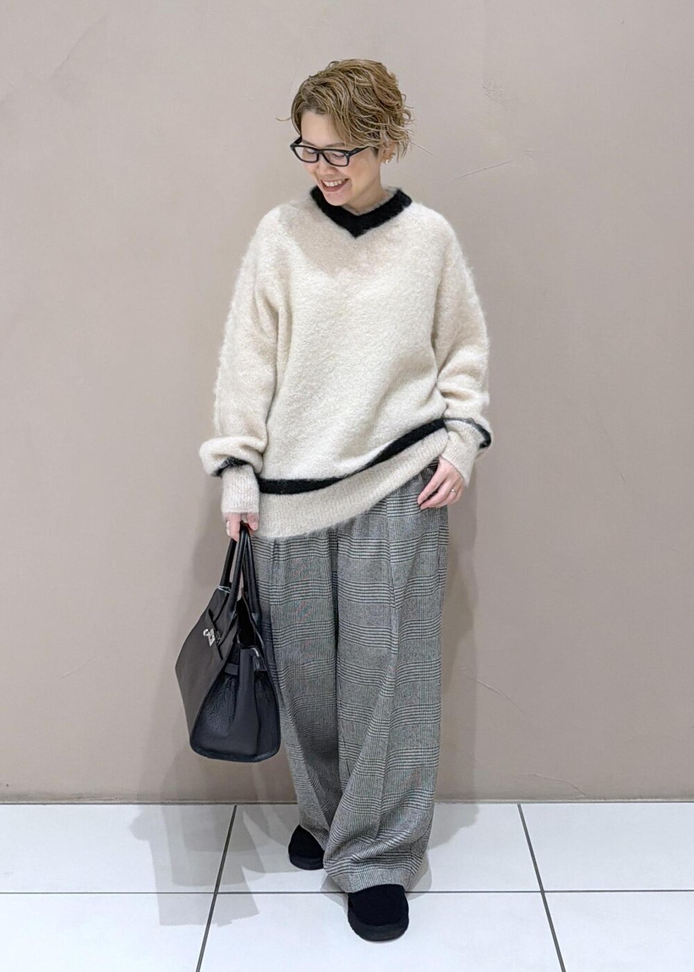 グレー系のスラックス、ブラック系のブーツを着用したレディースの冬コーディネートの3枚目の写真