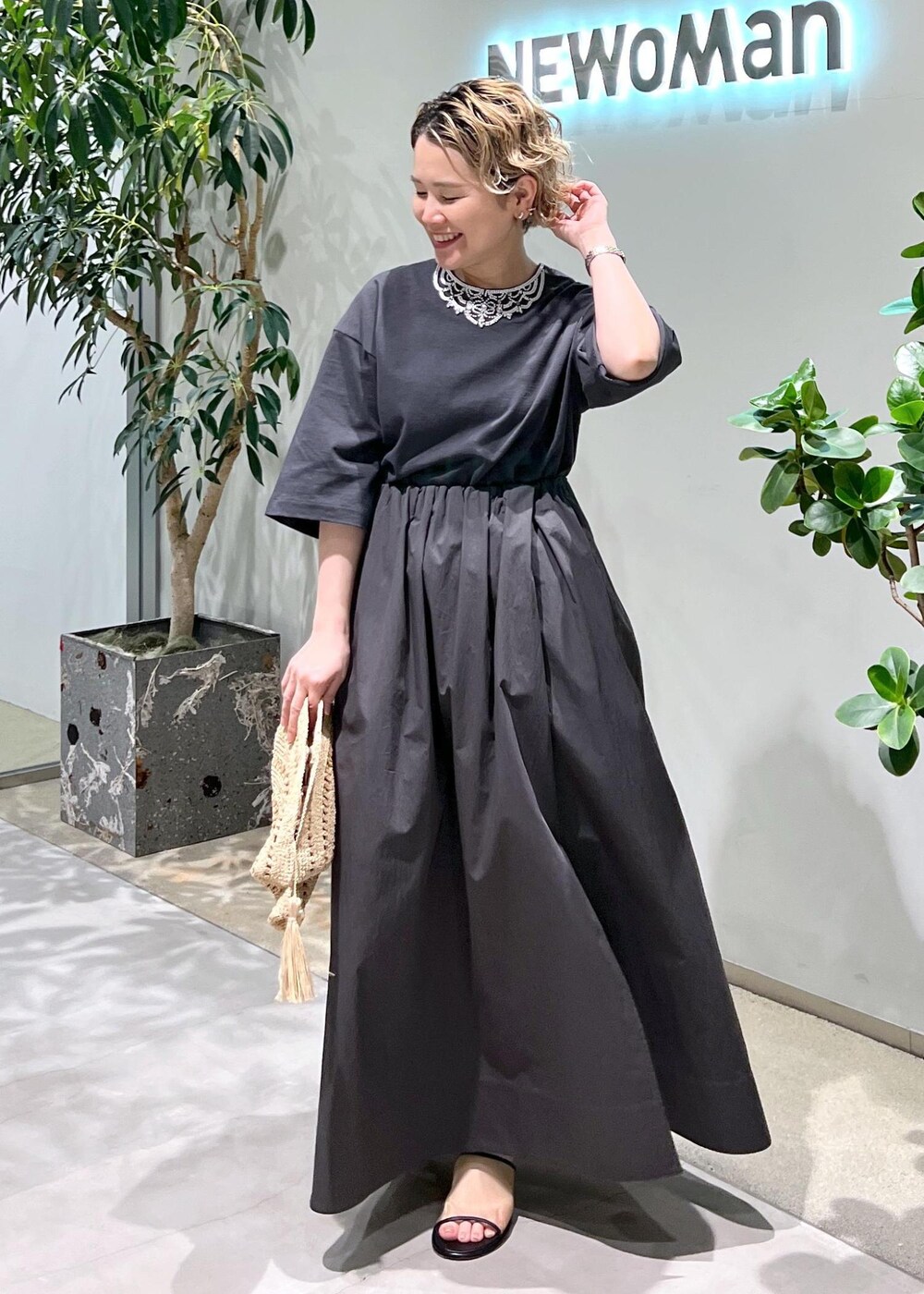 グレー系のスカート、グレー系のTシャツ/カットソー、ホワイト系のサンダルを着用したレディースの春コーディネートの5枚目の写真