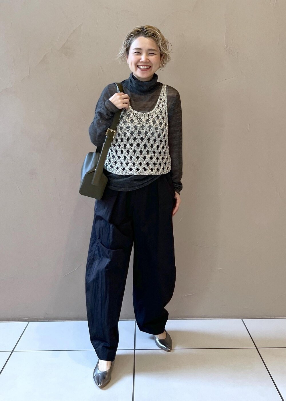 シルバー系のベスト、グレー系のニット/セーター、ブラック系のその他パンツを着用したレディースの秋コーディネートの3枚目の写真