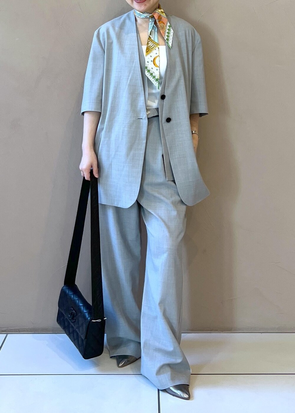 グレー系のベスト、グレー系のスラックス、グレー系のテーラードジャケットを着用したレディースの冬コーディネートの7枚目の写真