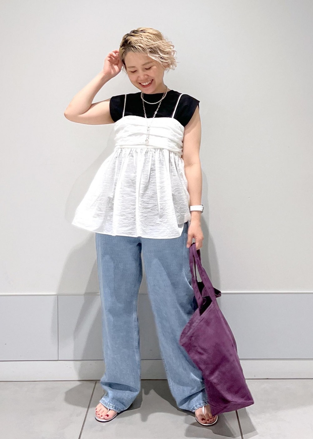 シルバー系のサンダル、ブラック系のTシャツ/カットソー、ホワイト系のキャミソールを着用したレディースの夏コーディネートの2枚目の写真