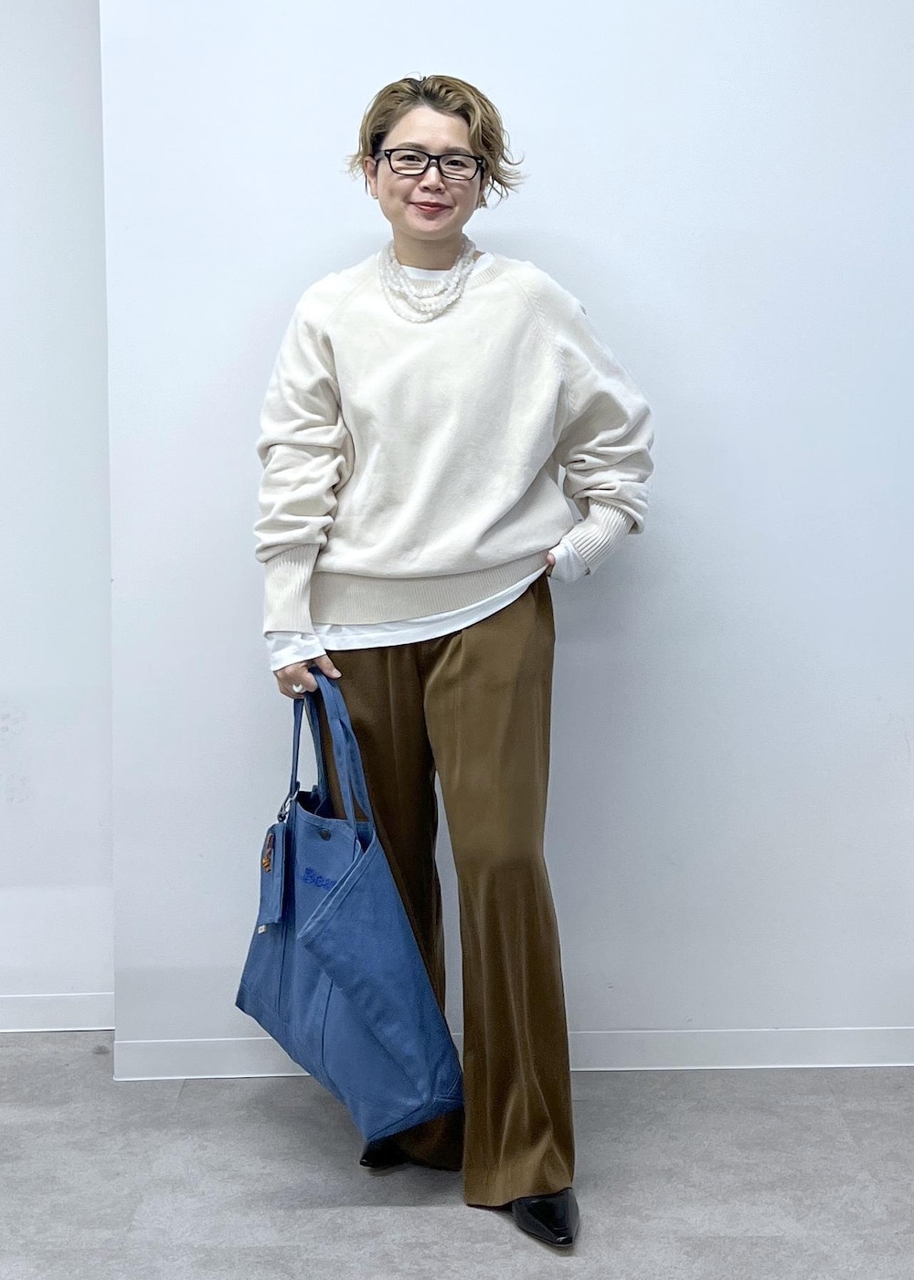 ホワイト系のスウェット、ブラウン系のその他パンツ、ブラック系のローファーを着用したレディースの秋コーディネートの3枚目の写真