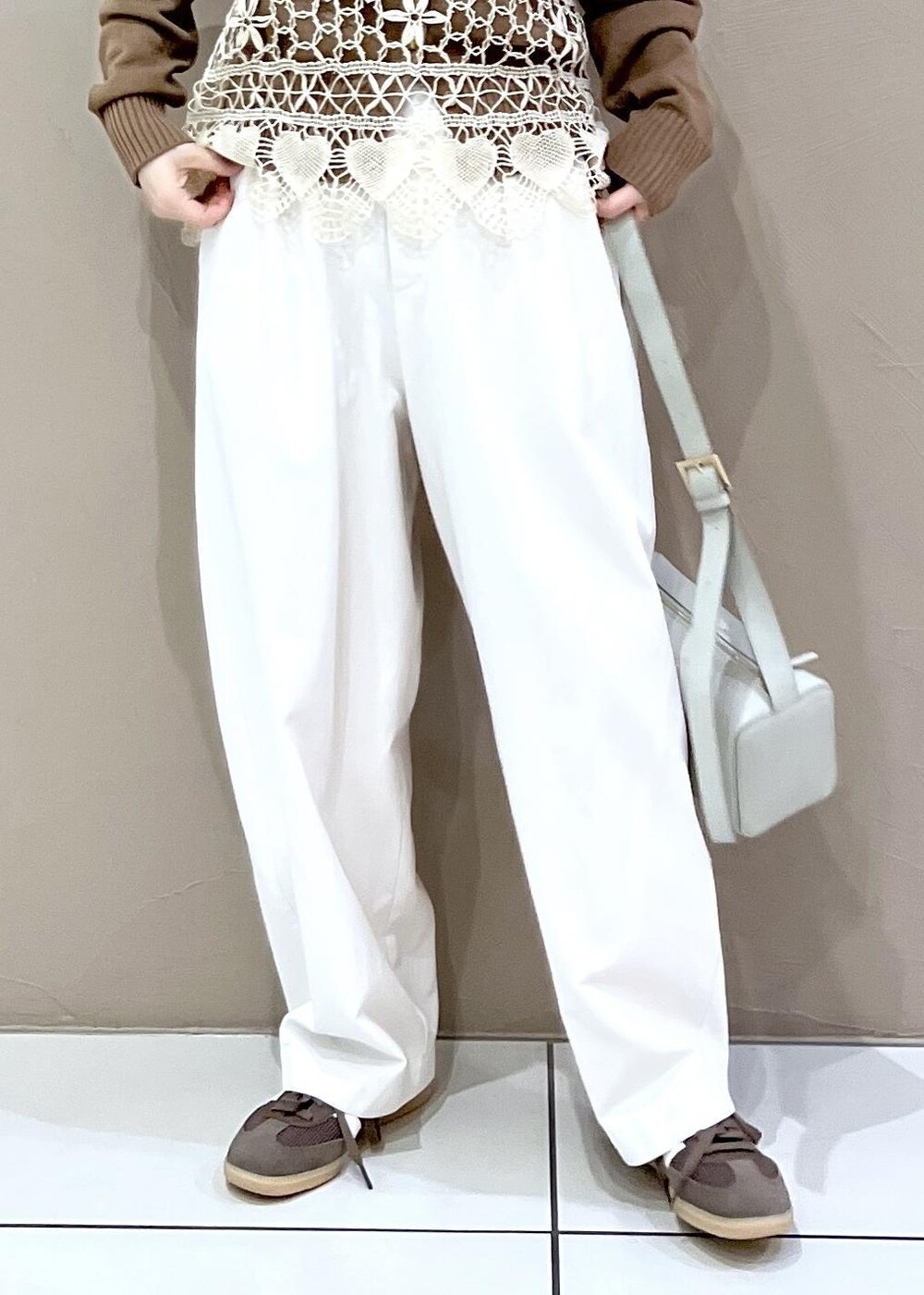 グレー系のショルダーバッグ、ホワイト系のその他パンツ、イエロー系のカーディガン/ボレロを着用したレディースの春コーディネートの7枚目の写真