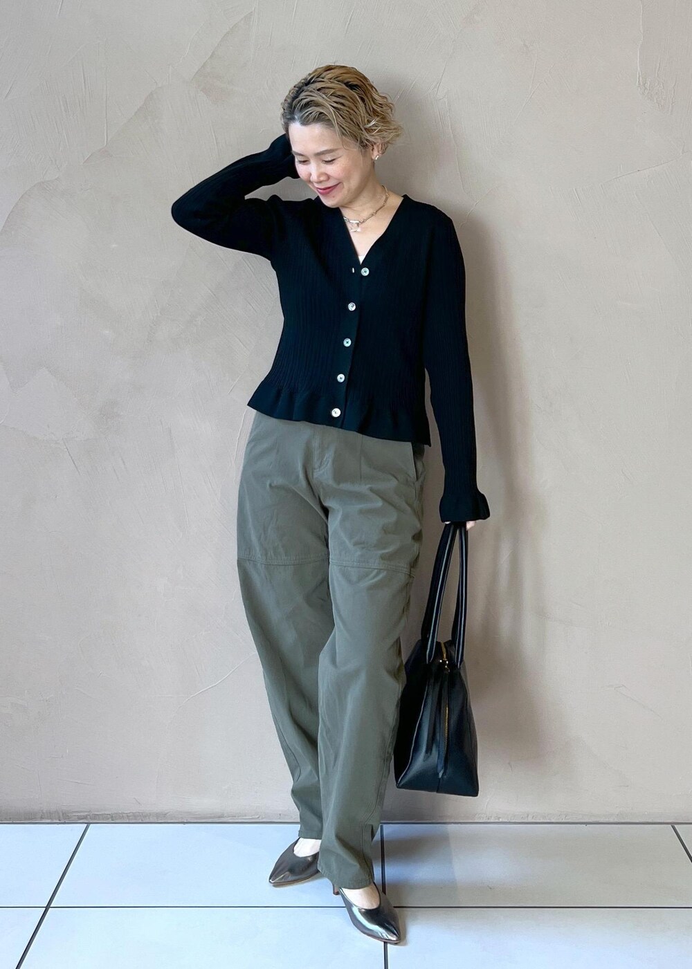 ブラック系のカーディガン/ボレロ、グリーン系のその他パンツ、ブラック系のボストンバッグを着用したレディースの冬コーディネートの3枚目の写真