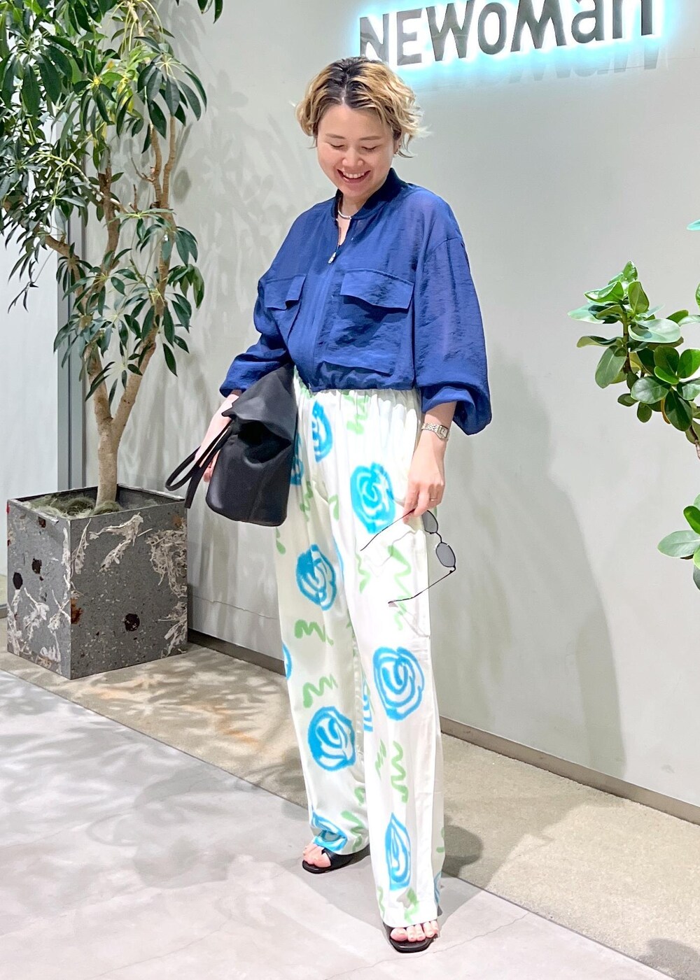 ブラック系のサンダル、ブルー系のブルゾン、ブラック系のサングラスを着用したレディースの春コーディネートの4枚目の写真