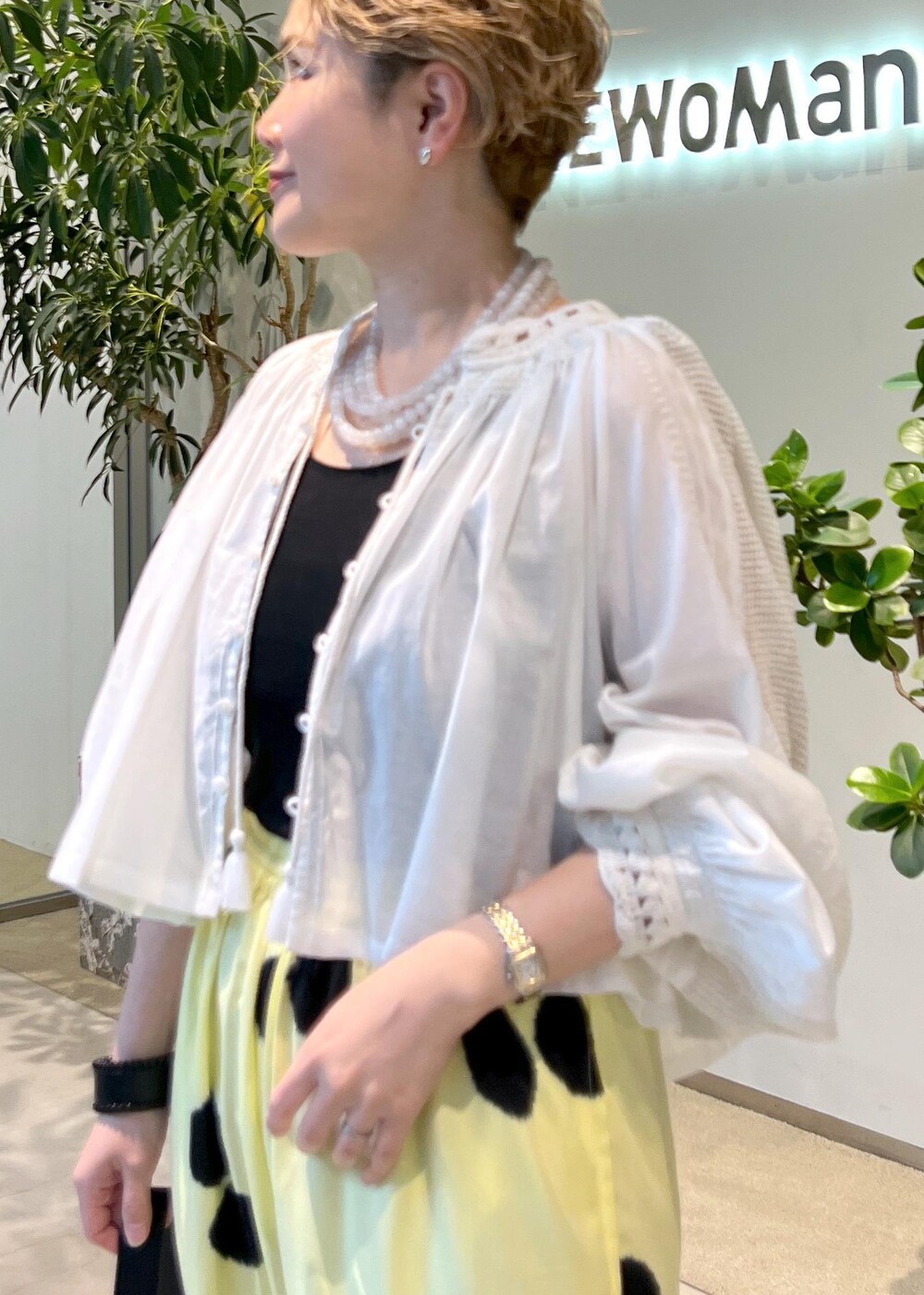 ブラック系のショルダーバッグ、ホワイト系のシャツ/ブラウス、ホワイト系のサンダルを着用したレディースの夏コーディネートの5枚目の写真