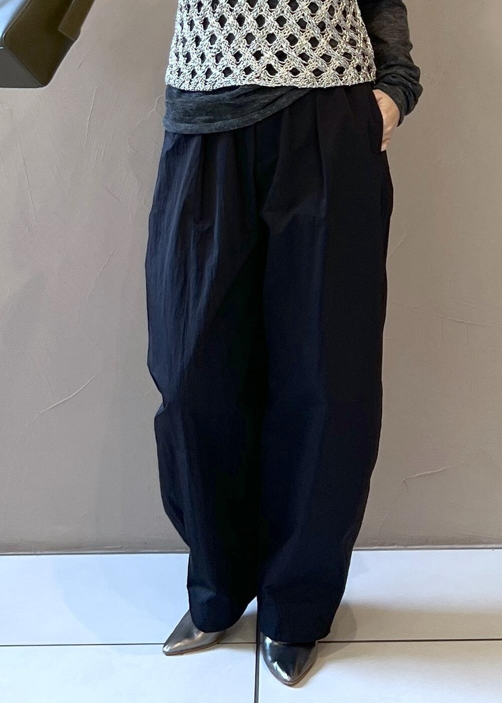 シルバー系のベスト、グレー系のブルゾン、グレー系のニット/セーターを着用したレディースの秋コーディネートの9枚目の写真