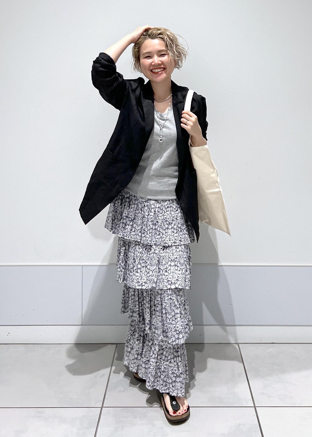 ブラック系のテーラードジャケット、ブラック系のスカートを着用したレディースの夏コーディネートの5枚目の写真