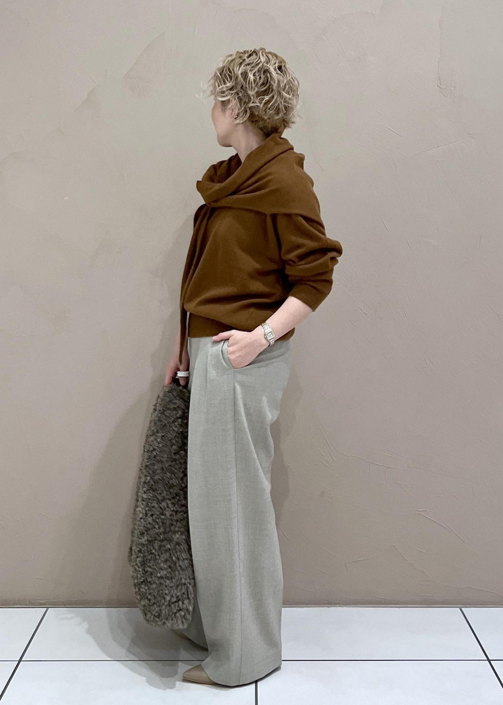 ベージュ系のスラックス、ブラウン系のトートバッグ、イエロー系のニット/セーターを着用したレディースの秋コーディネートの4枚目の写真