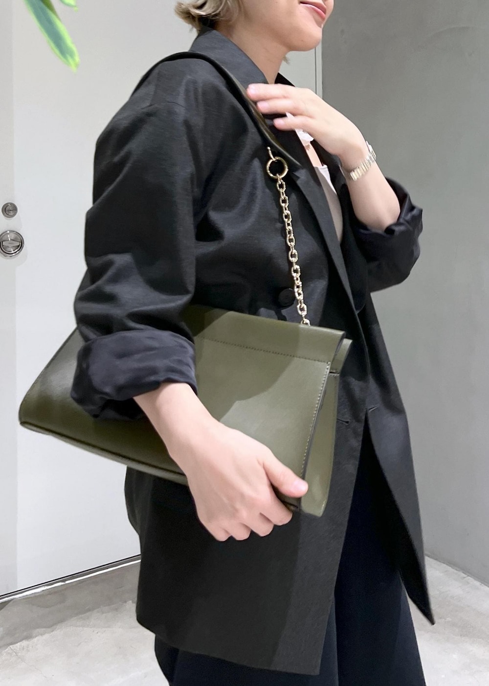 グリーン系のショルダーバッグ、ブラック系のスウェットパンツ、シルバー系のパンプスを着用したレディースの秋コーディネートの6枚目の写真