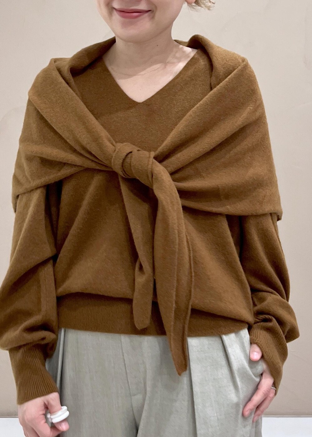 ベージュ系のスラックス、ブラウン系のトートバッグ、イエロー系のニット/セーターを着用したレディースの秋コーディネートの6枚目の写真