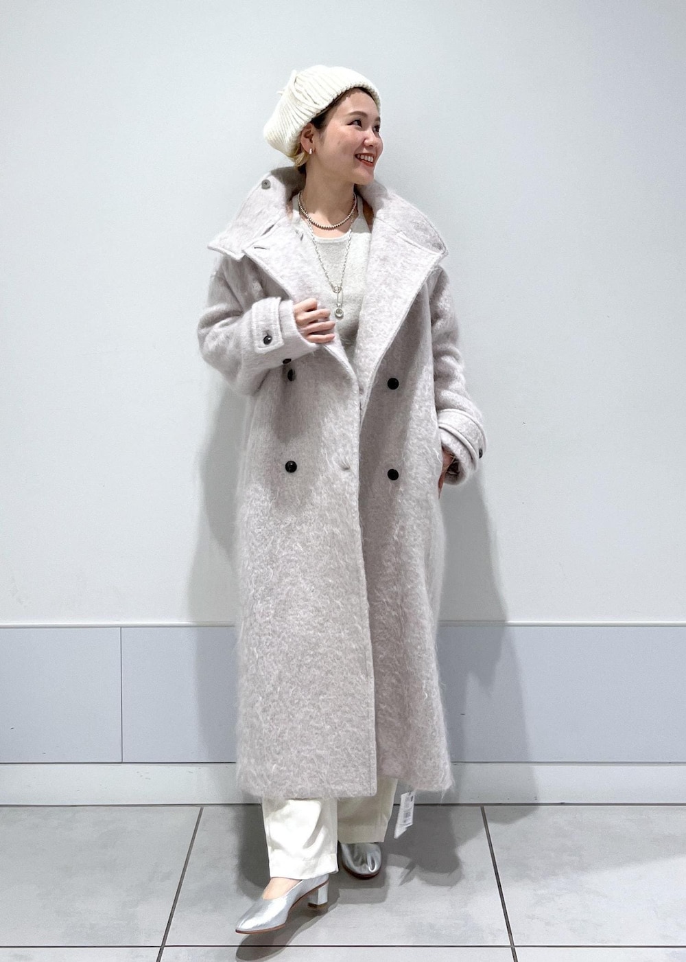 グレー系のその他アウター、ホワイト系のキャミソール、ホワイト系のカーゴパンツを着用したレディースの冬コーディネートの2枚目の写真