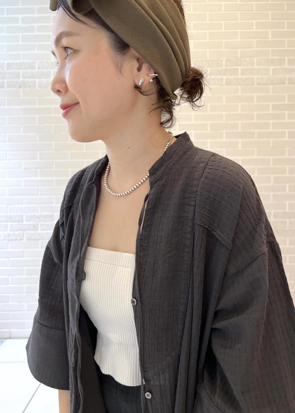 ホワイト系のチューブトップ、ベージュ系のサンダル、ブラック系のシャツ/ブラウスを着用したレディースの夏コーディネートの5枚目の写真