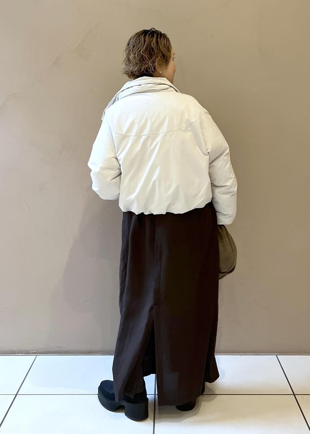 ホワイト系のダウンジャケット/コート、グレー系のハンドバッグ、グレー系のワンピースを着用したレディースの秋コーディネートの7枚目の写真