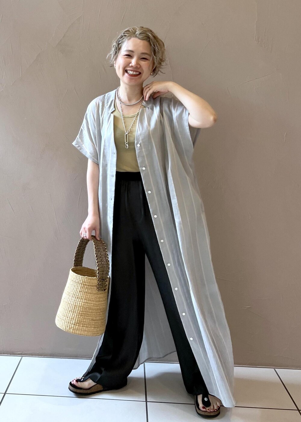 ブラック系のその他パンツ、イエロー系のタンクトップ、ブルー系のワンピースを着用したレディースの夏コーディネートの4枚目の写真