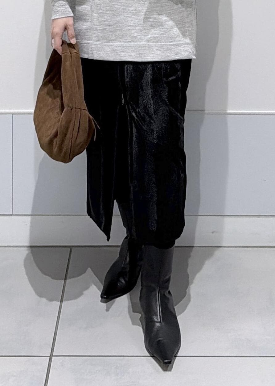 ブラック系のスカート、ブラウン系のハンドバッグ、ブラック系のブーツを着用したレディースの秋コーディネートの7枚目の写真