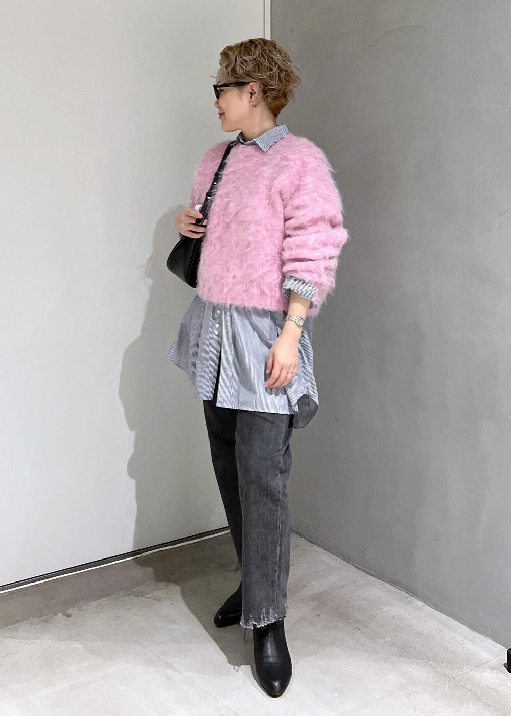 ブラック系のブーツ、ピンク系のニット/セーター、ブラック系のデニムパンツを着用したレディースの秋コーディネートの5枚目の写真