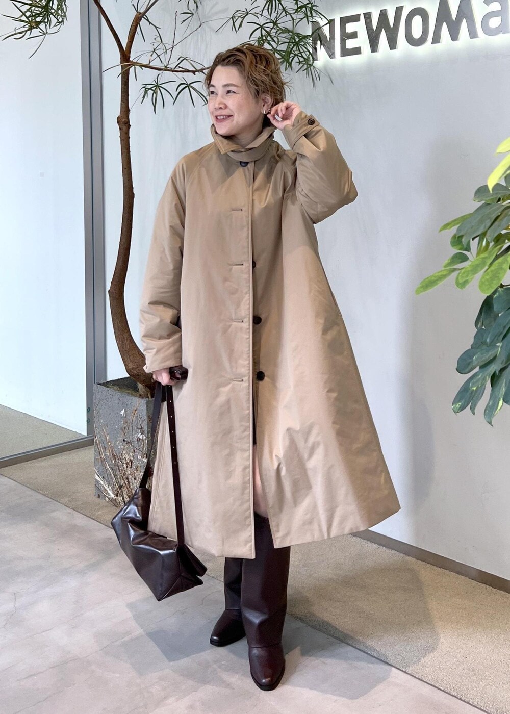 ブラウン系のブーツ、ブラウン系のショルダーバッグ、ベージュ系のダウンジャケット/コートを着用したレディースの秋コーディネートの7枚目の写真